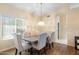 This bright dining room includes a wooden table, six upholstered chairs, and a decorative chandelier at 8958 W Rosemonte Dr, Peoria, AZ 85382