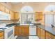 This functional kitchen features light wood cabinets and a window providing natural light above the sink at 8958 W Rosemonte Dr, Peoria, AZ 85382