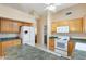 This kitchen boasts ample counter space, wooden cabinetry, and modern white appliances under a vaulted ceiling at 8958 W Rosemonte Dr, Peoria, AZ 85382