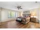 Spacious main bedroom with wood-look flooring, ceiling fan, ensuite access, and natural light from the large window at 8958 W Rosemonte Dr, Peoria, AZ 85382
