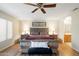Bright main bedroom with wood-look flooring, a ceiling fan, matching nightstands, and a decorative headboard at 8958 W Rosemonte Dr, Peoria, AZ 85382