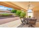 Covered patio featuring a table and chairs perfect for outdoor dining with a view of the landscaped backyard at 8958 W Rosemonte Dr, Peoria, AZ 85382