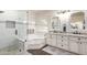 A bright bathroom features a glass shower, soaking tub, dual sink vanity with granite countertop at 9569 W Redbird Rd, Peoria, AZ 85383