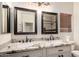 Bathroom with a dual-sink vanity, granite countertops, and dark wood framed mirrors at 9569 W Redbird Rd, Peoria, AZ 85383