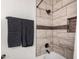 Elegant bathroom featuring a tiled shower, dark fixtures, and convenient built-in shelving at 9569 W Redbird Rd, Peoria, AZ 85383