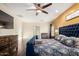 An airy bedroom with a blue upholstered bed and decorative bedding, wood flooring, and a ceiling fan at 9569 W Redbird Rd, Peoria, AZ 85383