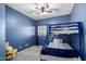 A blue-walled bedroom features a bunk bed, carpeted floor and window with neutral-colored blinds at 9569 W Redbird Rd, Peoria, AZ 85383