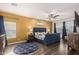 Spacious bedroom with a blue upholstered bed, decorative rug, wood floors, and great natural light at 9569 W Redbird Rd, Peoria, AZ 85383