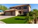Two-story home with a tile roof, well-manicured lawn, and lush tropical landscaping at 9569 W Redbird Rd, Peoria, AZ 85383