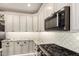 Modern kitchen with white cabinets, stainless steel microwave, and stunning granite countertops at 9569 W Redbird Rd, Peoria, AZ 85383
