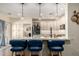 Modern kitchen with granite countertops, stainless steel appliances, pendant lighting, and counter seating for three at 9569 W Redbird Rd, Peoria, AZ 85383