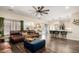 Spacious living room that opens up into the kitchen, featuring stylish decor and dark wood-look flooring at 9569 W Redbird Rd, Peoria, AZ 85383