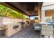 Covered outdoor kitchen featuring a built-in grill, counter space, and bar seating area at 9569 W Redbird Rd, Peoria, AZ 85383