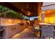 Outdoor kitchen with built-in grill, counter space, and dining area beneath a stylish pergola at 9569 W Redbird Rd, Peoria, AZ 85383