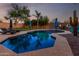 Backyard pool area with lush landscaping, a lounge area, mature trees, and a desert landscape at 9569 W Redbird Rd, Peoria, AZ 85383