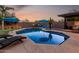 Inviting backyard pool with lounge chairs, umbrellas, and outdoor kitchen area, perfect for entertaining at 9569 W Redbird Rd, Peoria, AZ 85383