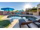 Sparkling pool area with lounge chairs and a built-in outdoor kitchen under sunny skies at 9569 W Redbird Rd, Peoria, AZ 85383