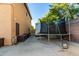 Side yard with access to yard storage and featuring a trampoline at 9569 W Redbird Rd, Peoria, AZ 85383