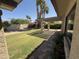 Backyard featuring green grass, blooming flowers, mature landscaping, and covered patio at 10190 N 106Th E St, Scottsdale, AZ 85258