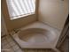 Soaking tub in a bright bathroom, complemented by natural light from a large window at 10190 N 106Th E St, Scottsdale, AZ 85258