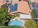 Aerial view featuring a private backyard pool and spa, with solar panels installed on the home's roof and lush landscaping at 10367 E Wood Dr, Scottsdale, AZ 85260