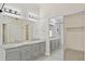 Bathroom with double sinks, granite countertop, mirrors, and a shower at 10367 E Wood Dr, Scottsdale, AZ 85260
