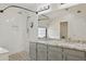 Bathroom featuring a double vanity and a walk-in shower with white tile at 10367 E Wood Dr, Scottsdale, AZ 85260
