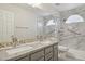 Bathroom with double sinks, granite countertop, and walk-in shower with mosaic tiling and grab bars at 10367 E Wood Dr, Scottsdale, AZ 85260