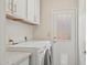 Laundry room with white washer and dryer, white cabinets, granite counters, and exterior door at 10367 E Wood Dr, Scottsdale, AZ 85260