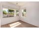 Cozy bedroom with natural light, wood-look floors, and views of the outdoor scenery at 1213 W Beck Ln, Phoenix, AZ 85023