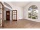 Inviting entryway with wood-look tile, arched window, and a decorative wood door at 1213 W Beck Ln, Phoenix, AZ 85023