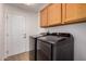Modern laundry room featuring updated cabinets, a washing machine, and a dryer at 1213 W Beck Ln, Phoenix, AZ 85023