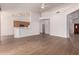 Spacious living area featuring wood-look tile floors, white walls, and a view to the kitchen at 1213 W Beck Ln, Phoenix, AZ 85023