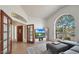 Spacious living room with vaulted ceilings, a fireplace, and a large arched window showcasing the neighborhood at 1213 W Beck Ln, Phoenix, AZ 85023