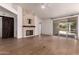 Bright living room featuring a stone fireplace, light wood floors, and sliding glass doors to the outside at 1213 W Beck Ln, Phoenix, AZ 85023