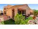 Desert backyard with a covered patio, synthetic grass, and mature landscaping at 14428 W Moccasin Trl, Surprise, AZ 85374