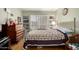 A partial view of a bright bedroom with a vintage-style bed frame and window with shutters at 14428 W Moccasin Trl, Surprise, AZ 85374