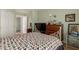 Well-lit bedroom with hardwood floors, a comfortable quilt, and a view of the closet and bathroom at 14428 W Moccasin Trl, Surprise, AZ 85374