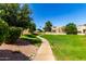 Well-maintained community with lush landscaping and a walking path at 14428 W Moccasin Trl, Surprise, AZ 85374
