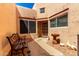 Enclosed courtyard with seating, mature landscaping, and a charming front door at 14428 W Moccasin Trl, Surprise, AZ 85374