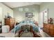 Spacious main bedroom featuring a white metal bed frame, ceiling fan, three windows, and light green walls at 14428 W Moccasin Trl, Surprise, AZ 85374