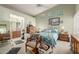 Bright main bedroom with a white metal bed frame, ceiling fan, sitting area, and ensuite bathroom access at 14428 W Moccasin Trl, Surprise, AZ 85374