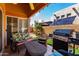 Inviting covered patio with comfortable seating, a grill, and a view of the private backyard at 14428 W Moccasin Trl, Surprise, AZ 85374