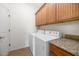 Functional laundry room featuring a washer, dryer, granite countertop, and ample cabinet space at 14815 N Fountain Hills Blvd # 201, Fountain Hills, AZ 85268