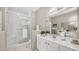 Bright bathroom featuring white vanity, large mirror, and glass enclosed shower with a towel rack at 15252 N 100Th St # 1164, Scottsdale, AZ 85260