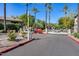 Gated community entrance featuring lush landscaping, mature palm trees, and security cameras for added peace of mind at 15252 N 100Th St # 1164, Scottsdale, AZ 85260
