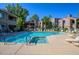 Sparkling community pool with lounge chairs, shaded umbrellas, and mature trees providing a serene oasis at 15252 N 100Th St # 1164, Scottsdale, AZ 85260