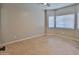 Cozy bedroom features tile flooring, neutral walls, a ceiling fan, and two windows at 15354 W Caribbean Ln, Surprise, AZ 85379