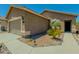 Inviting front exterior with desert landscaping, walkway to the front door, and a two-car garage at 15354 W Caribbean Ln, Surprise, AZ 85379