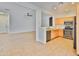 Open-concept kitchen featuring stainless steel appliances, tile floors and seamless transition to the living room at 15354 W Caribbean Ln, Surprise, AZ 85379